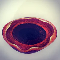 a bowl with a red and black design on it